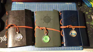 Three customized notebooks tied shut with personalized pendants.
