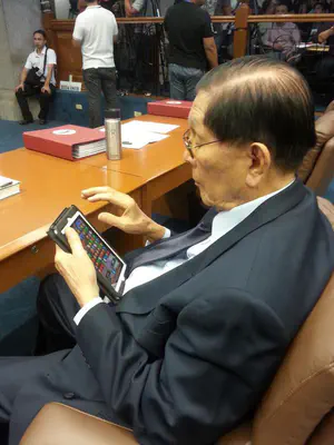Counsellor Juan Ponce Enrile playing Bejewelled on his mobile device during a recess in Congress.