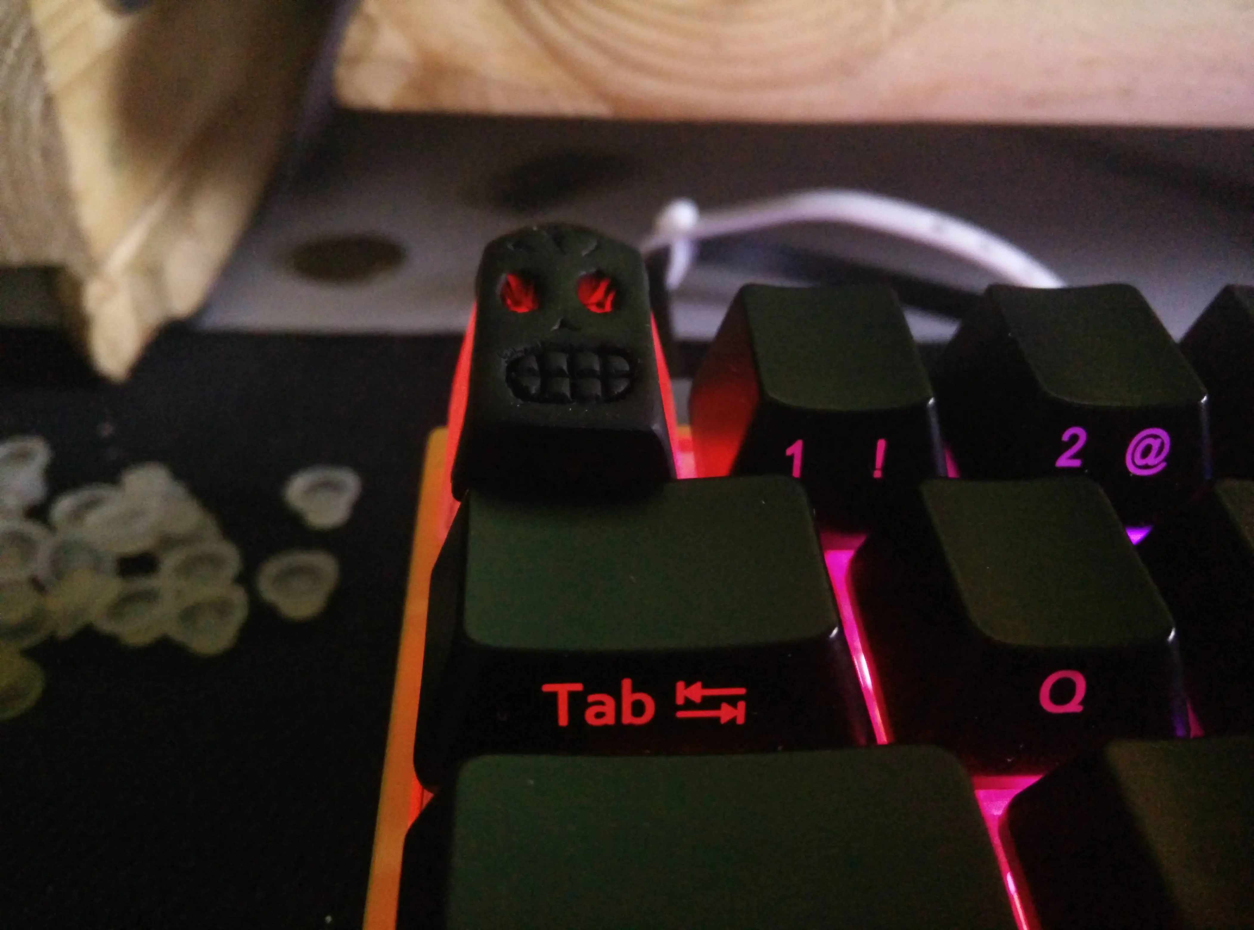 Photo of a badly-made Cherry MX-compatible keycap in the shape of Grim Fandango star Manny Calavera's head.