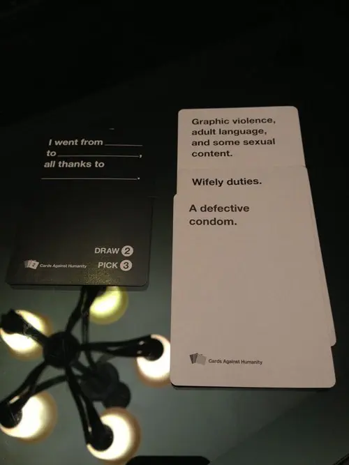 Cards Against Humanity combo. Black card: “I went from (blank) to (blank), all thanks to (blank).” White card 1: “Graphic violence, adult language, and some sexual content.” White card 2: “Wifely duties.” White card 3: “A defective condom.”