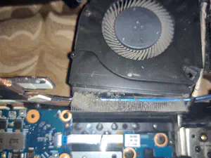 A large accumulation of dust and debris in the laptop's exhaust fan assembly.